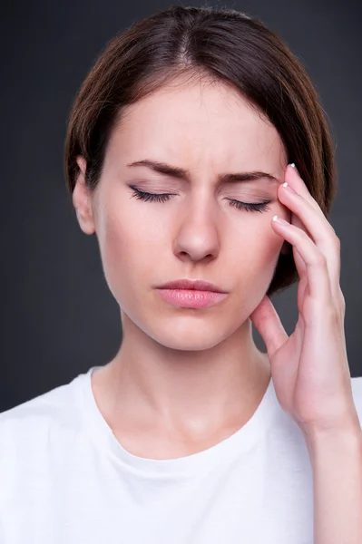 Jovem mulher tem uma dor de cabeça — Fotografia de Stock