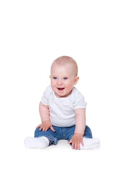 Söt liten pojke sitter på golvet och ler — Stockfoto