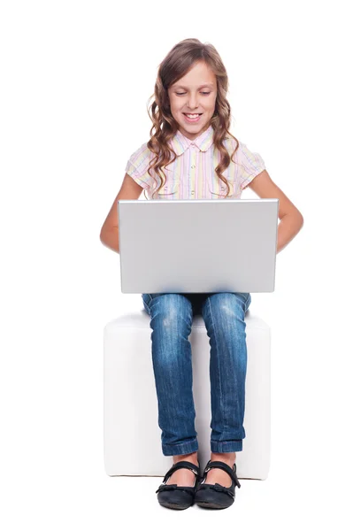 Маленькая симпатичная девушка смотрит на ноутбук — стоковое фото
