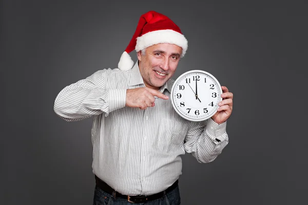 Homem em santa chapéu apontando para o relógio — Fotografia de Stock