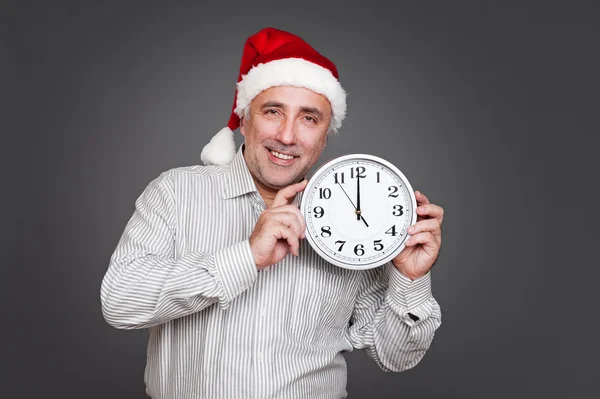 Animado homem com santa chapéu segurando relógio — Fotografia de Stock