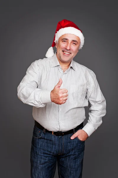 Mann mit Weihnachtsmütze zeigt Daumen hoch — Stockfoto