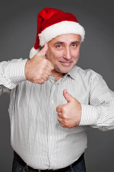 Mann mit Weihnachtsmütze zeigt Daumen hoch — Stockfoto