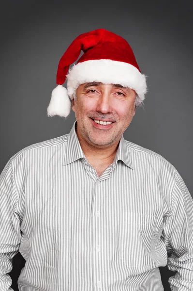 Usměvavý starší muž v červeném klobouku santa — Stock fotografie