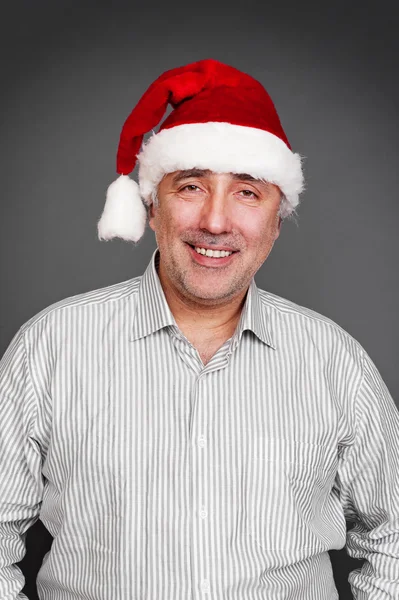 Sorridente sênior homem em vermelho santa chapéu — Fotografia de Stock