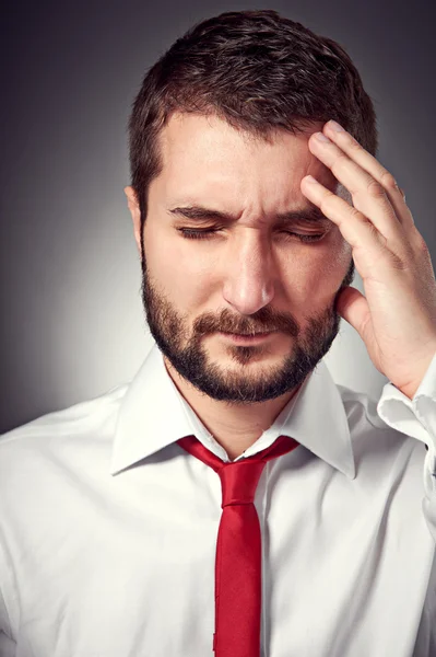 Uomo con mal di testa su sfondo grigio — Foto Stock