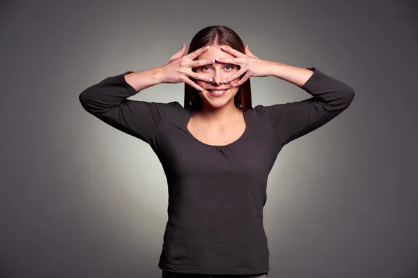 Woman looking through her fingers — Stock Photo, Image