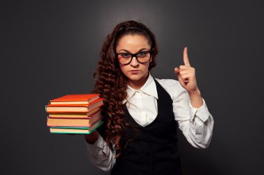 yığın kitap ile gözlüklü genç öğretmen olun dikkat işareti