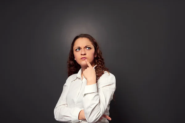 Divertente donna riccia pensando a qualcosa — Foto Stock