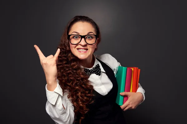 Fröhlicher Lehrer mit Büchern, die Zeichen der Hörner zeigen — Stockfoto