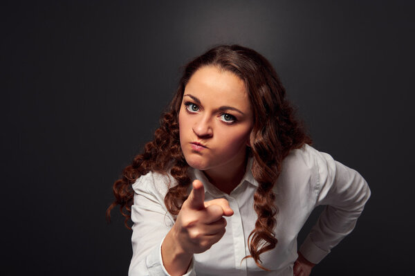 студийный кадр злой женщины, указывающей на камеру
