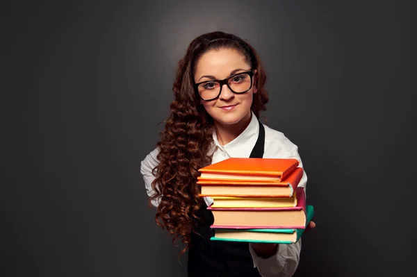 Junge Lehrerin bietet lächelnd Bücher an — Stockfoto