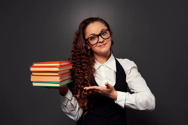 Mladá žena učitelka v brýlích nabízející knihy — Stock fotografie