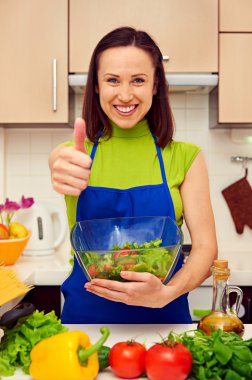 taze salata bir kase tutarak ve gösterilen ev hanımı thumbs-up