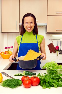 Spagetti ile tavada tutan ev kadını