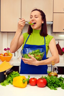 kadın mutfakta taze salata kaşığı tatma