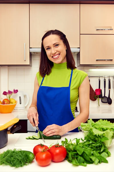 Femme au foyer préparant une salade dans la cuisine — Photo