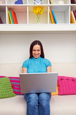 kanepede oturan ve laptop tutan kadın