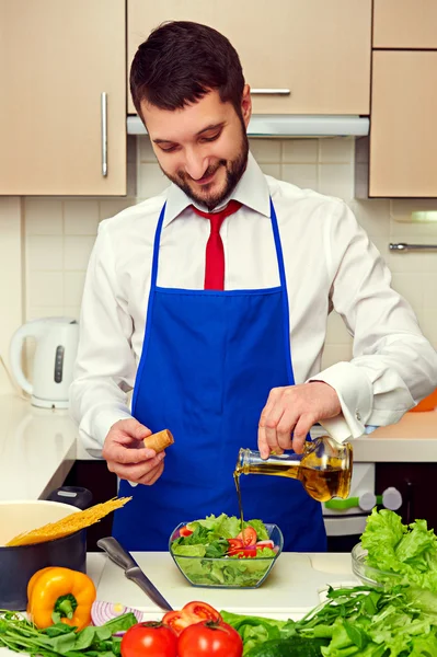 Человек добавляет оливковое масло в салат — стоковое фото