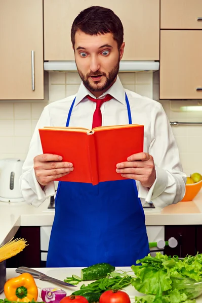 Hombre mirando en libro de cocina —  Fotos de Stock