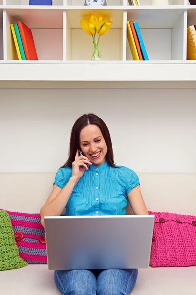 Kvinna sitter på soffan och prata i telefon — Stockfoto