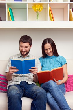 Çift kanepede oturan ve kitap okuma
