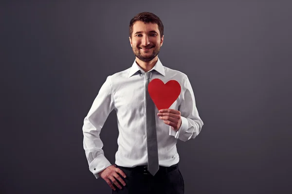 Hombre sosteniendo el corazón rojo y sonriendo — Foto de Stock