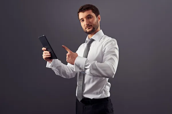 Joven adulto hombre de negocios apuntando a la tableta pc — Foto de Stock