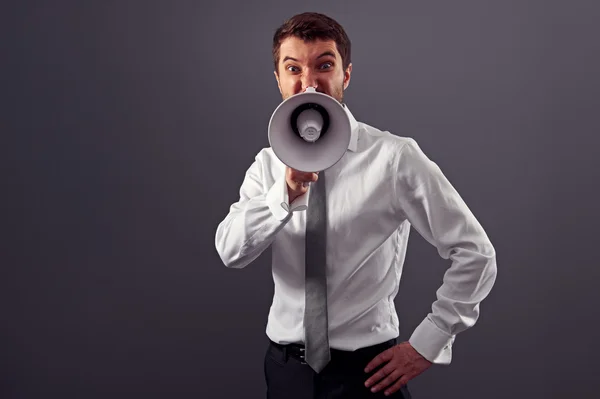 Young businessman screaming in megaphone — Stock Photo, Image