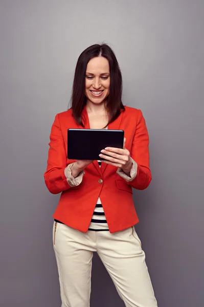 Girl using tablet pc and smiling — Stock Photo, Image