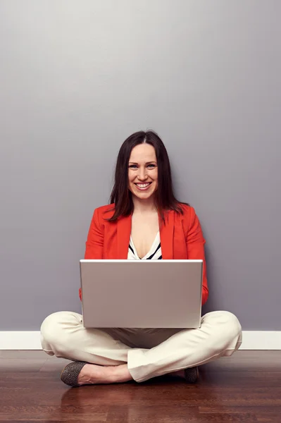 Boldog lány használ laptop, és mosolyogva — Stock Fotó