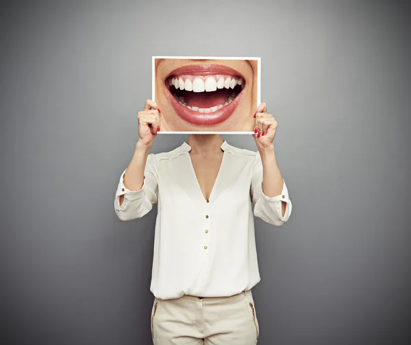 Woman holding picture with big smile — Stock Photo, Image