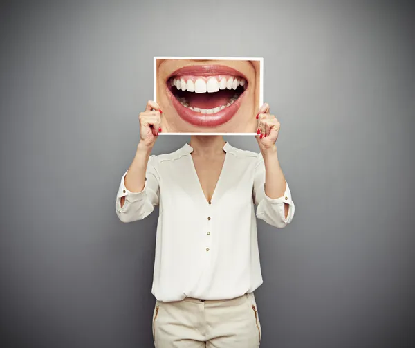 Mulher segurando foto com grande sorriso — Fotografia de Stock