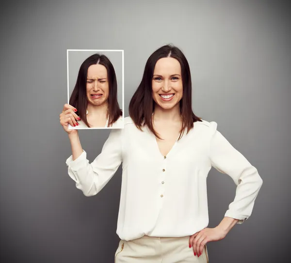 Mulher feliz segurando sua imagem triste Fotos De Bancos De Imagens