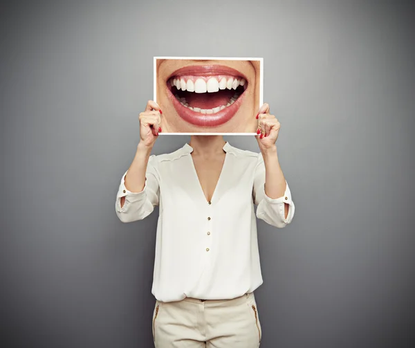 Mujer sosteniendo imagen con gran sonrisa Imagen de archivo