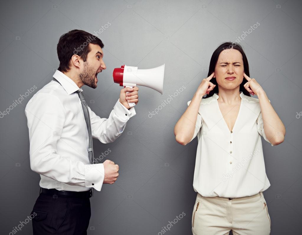 man screaming in megaphone at the woman