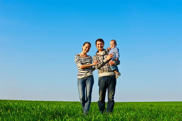 Família andando na grama verde — Fotografia de Stock