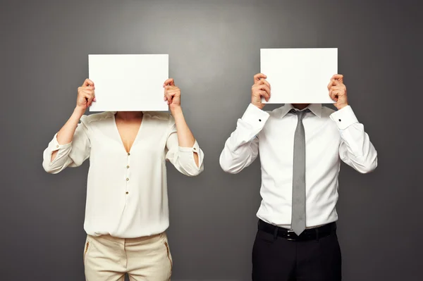 Muž a žena skrývá jejich tváře — Stock fotografie