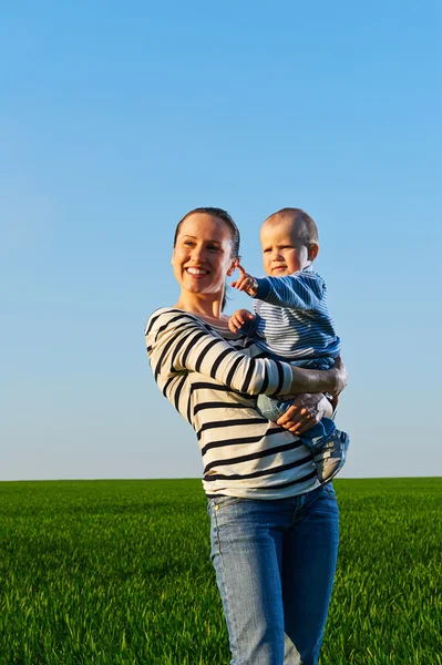 Anne oğlunu holding ve gülümseyerek — Stok fotoğraf