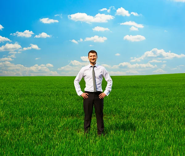 Yeşil çimenlerin üzerinde duran ve gülen adam — Stok fotoğraf