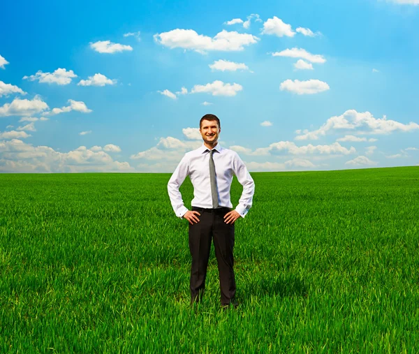 Man permanent op groene gras en glimlachen — Stockfoto