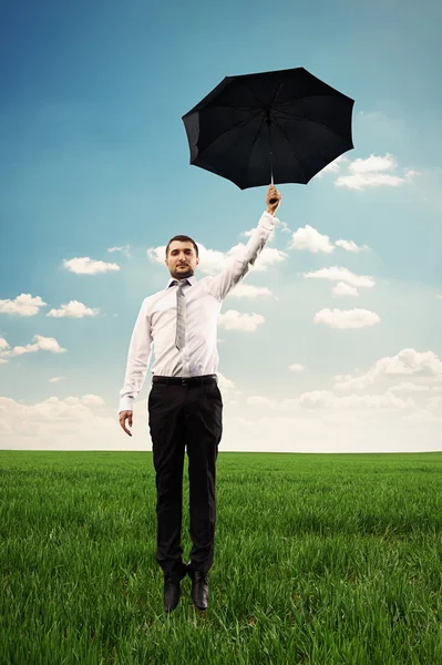 Homem voando com guarda-chuva preto — Fotografia de Stock