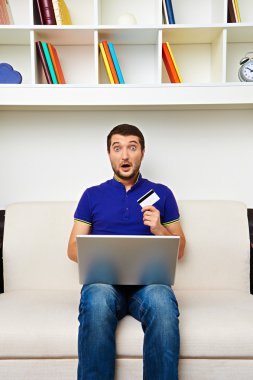 dizüstü bilgisayar ile genç adam parası onun kredi kartı yok.