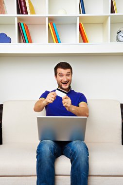 laptop ve kredi kartı tutan adam