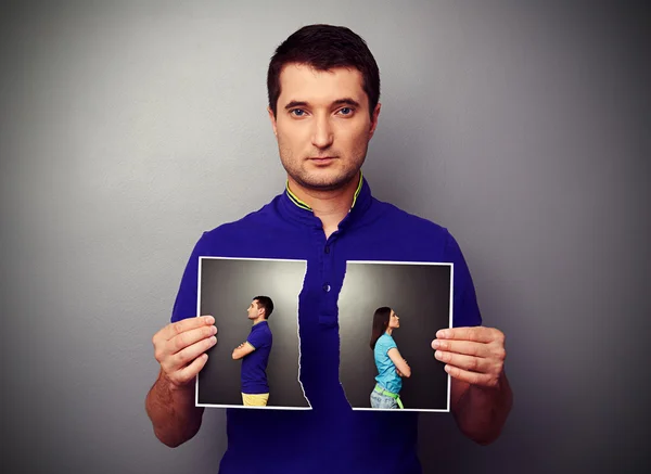 Jovem segurando a foto lacerada — Fotografia de Stock