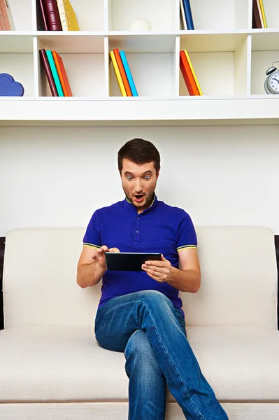 Překvapený muž při pohledu na počítači tablet pc — Stock fotografie