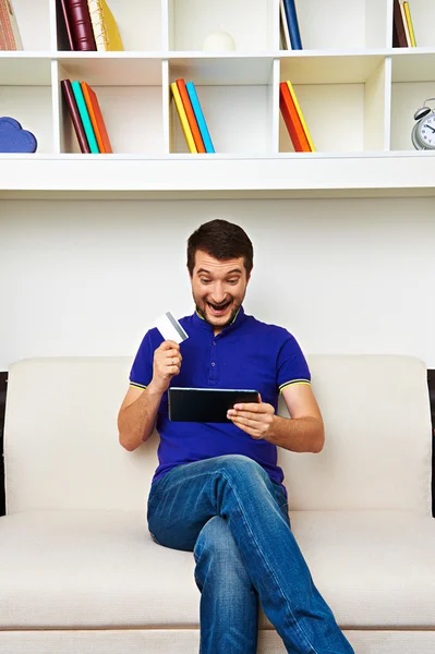 Homme avec tablette PC et carte de crédit à la maison — Photo
