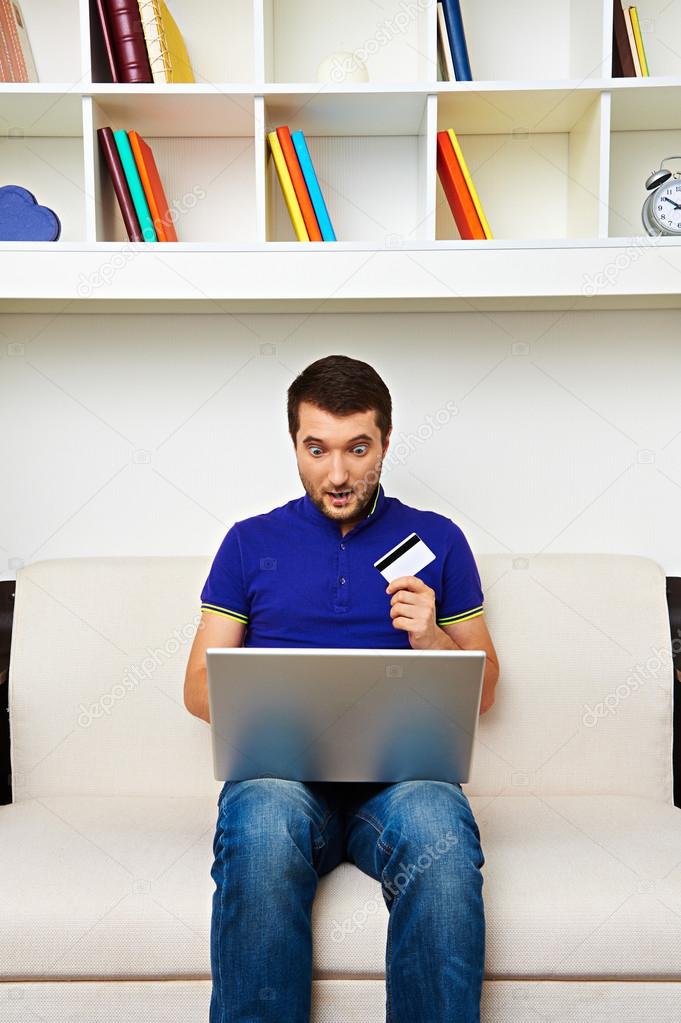 young man with laptop and credit card sitting
