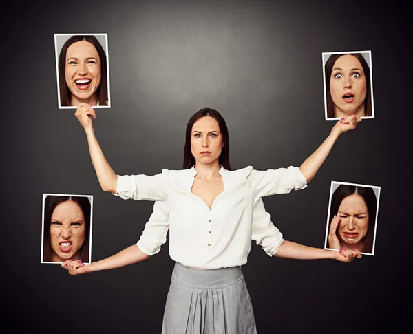Mujer sosteniendo imágenes con diferentes estados de ánimo — Foto de Stock