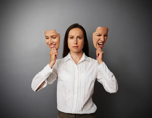 Žena držící dvě masky s jinou náladu — Stock fotografie
